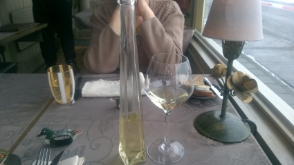 Glaasje wijn gepresenteerd in een glazen flesje.